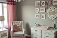a grey and pink vintage nursery with grey walls, white and creamy furniture, pink textiles, a gallery wall and a crystal chandelier