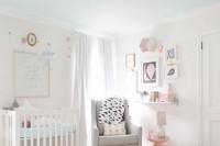 a peaceful white nursery with modern furniture, a grey chair and a pink side table, touches of brass and blue