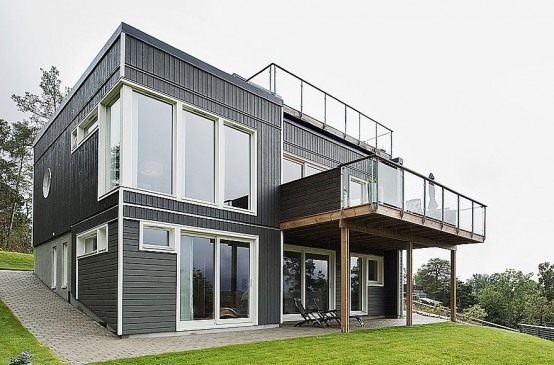 Swedish House With Dark Wooden Exterior And Detached Garage Near By