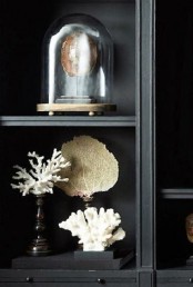 seaside home decor with corals on stands and just in the open shelving unit is a simple and lovely idea