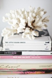 corals placed on top of a book stack is a lovely idea to give a seaside feel to the space
