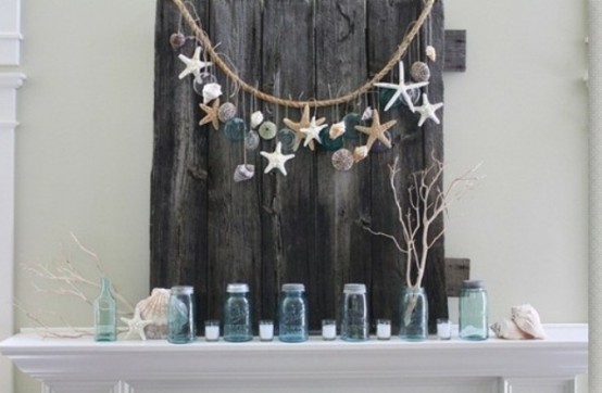 seashells, starfish, driftwood, blue jars, candles, a driftwood plank and a rope with seashells, starfish and blue floats