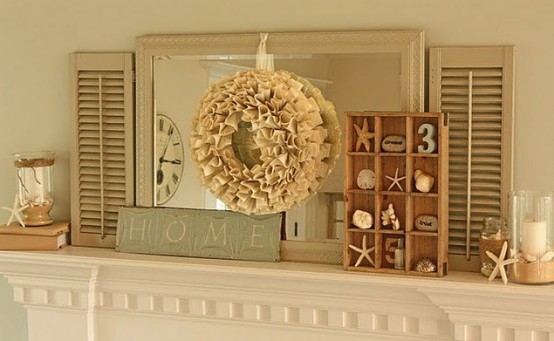a neutral beach mantel with a mirror, a burlap wreath, a box with seashells, starfish and candleholders with starfish