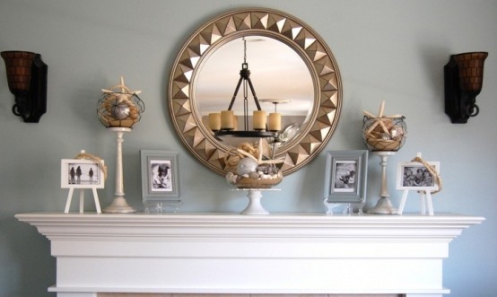 jars with beach sand, seashells and starfish, net and some photos on stands make the mantel feel beach-like