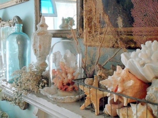 a cloche with a pink coral, more corals, starfish and seashells, vintage bottles and jars