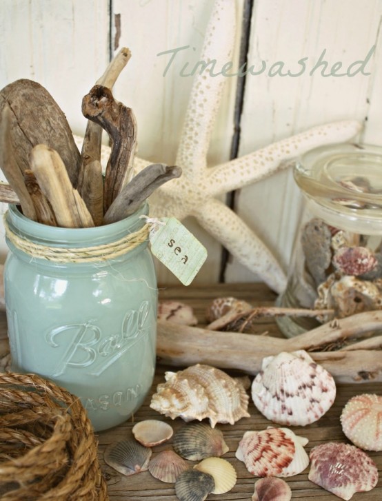 a mantel with seashells, starfish, jars with driftwood and seashells, rope looks beach-like and very enjoyable