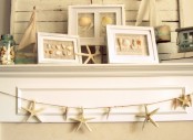 a neutral beach mantel with seashell artworks, starfish and a jar with seashells, a garland of starfish for a vacation-inspired mantel