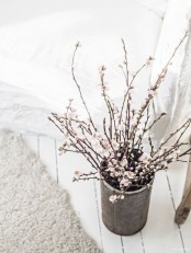 a concrete vase with blooming cherry branches is a great decoration and centerpiece for any space