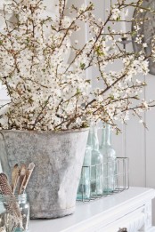 a vintage bucket with lots of blooming branches will bring a cozy rustic feel and a natural touch to the space