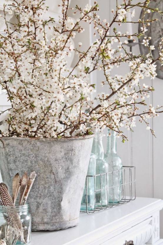 a vintage bucket with lots of blooming branches will bring a cozy rustic feel and a natural touch to the space