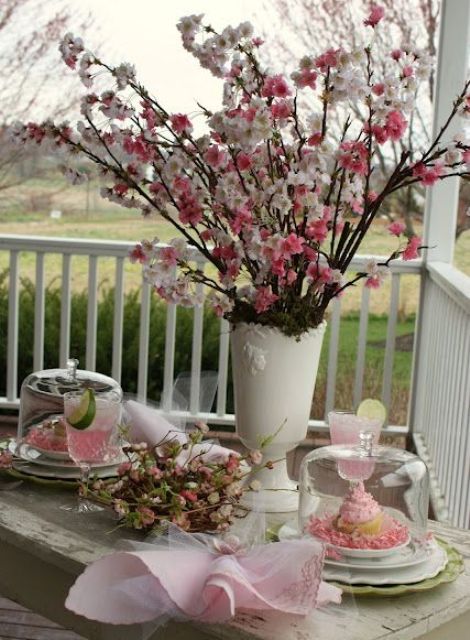 a white vase with pink and blush blooming branches is a beautiful spring or Easter decoration