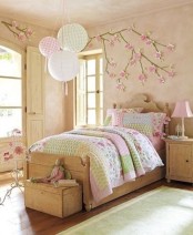 a vintage-inspired kid’s bedroom with cherry blossom on the wall that accents the decor of the room