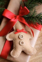 a felt gingerbread man cookie gift tag with a red bow and buttons is a pretty idea for Christmas