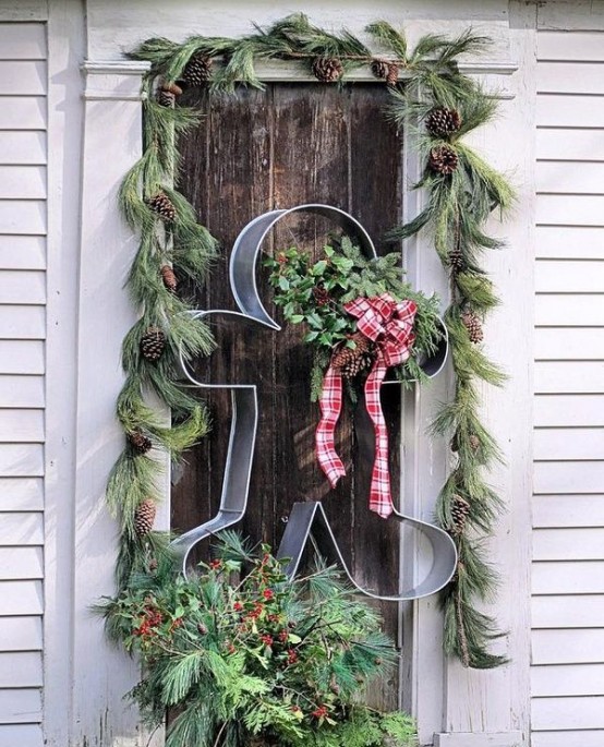 an alternative to a Christmas wreath - a metal gingerbread man cookie cutter with a burlap scarf and evergreens