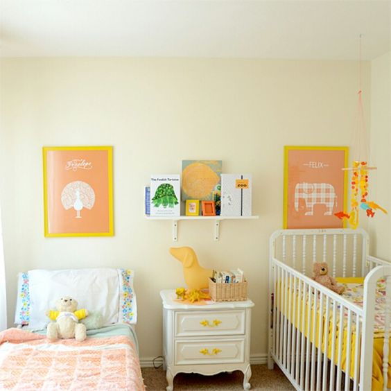 a warm-colored shared space done with touches of yellow, with artworks, toys and some bright bedding