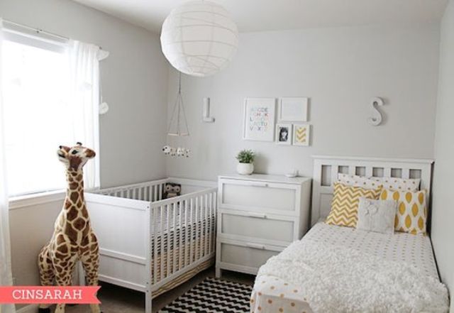 a cozy neutral shared nursery with neutral furniture, a paper lamp and a printed rug