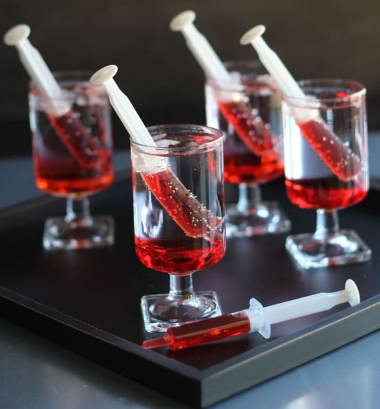 glasses with syringes filled with blood - style your Halloween party drinks like this to make it more fun and bold