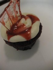 a bloody cupcke with a bloody suga glass shard is a veyr creative and bold treat or favor idea for a Dexter-themed Halloween party