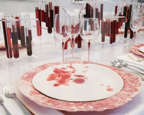 a Dexter themed tablescape with red chargers, test tubes with blood and bloody plates is a super cool idea for Halloween