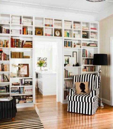 a doorway wall with open bookshelves is a cool idea to save some space while storing books and to use a blank wall over the door
