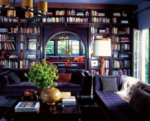 a whole wall covered with open bookshelves and with an arched doorway and a ladder is a smart way to store books saving space and to add chic to the space at the same time