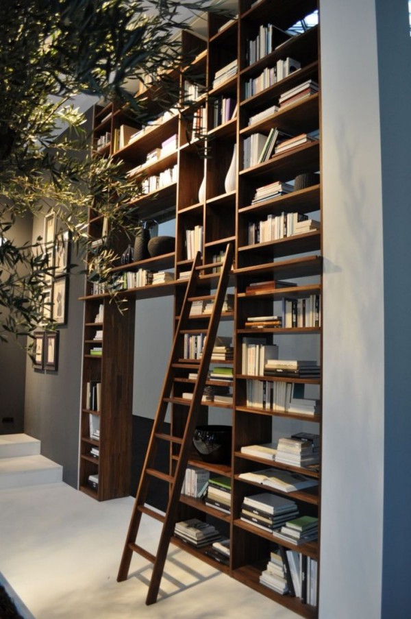 an open shelving unit of double height covering the whole doorway in the space is a cool idea to store and display things and make use of a double height ceiling