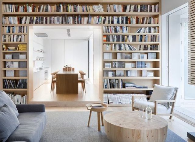 a doorway covered with bookshelves separates the living and dining room and creates a library right in the living room