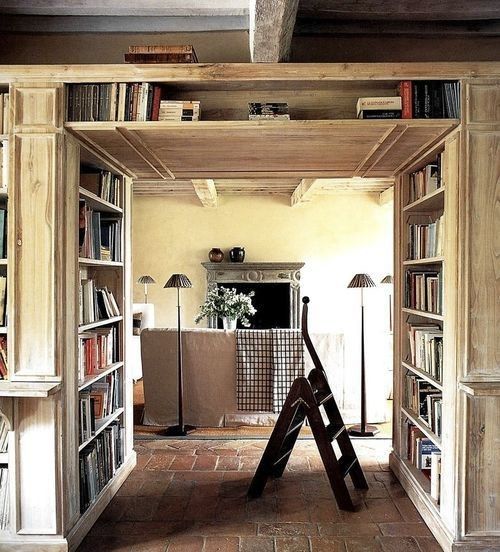 a large shelving unit for books placed in front of a doorway to store a lot of books and use the unused space in front of the doorway