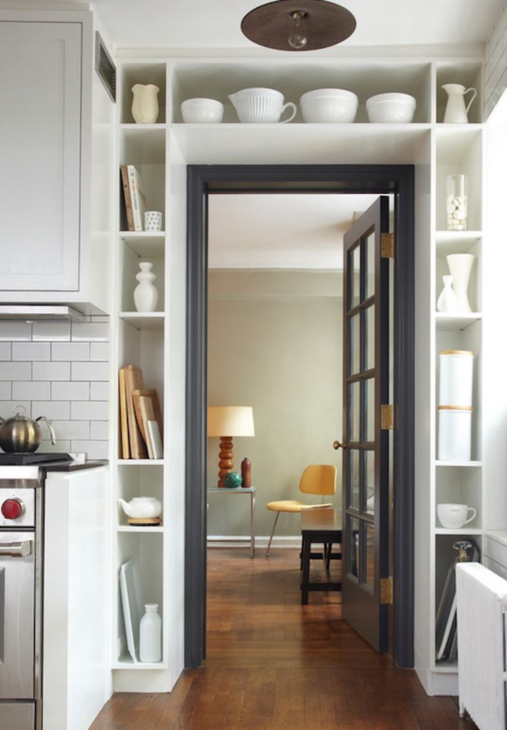 a doorway space taken by open shelves that display pretty tableware and cookware and some cutting boards is a lovely idea for every kitchen or dining room