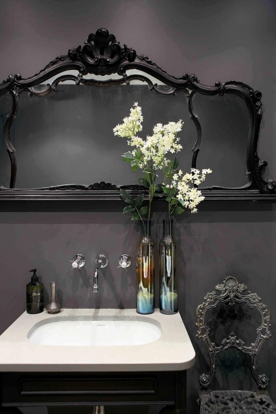 a chic Gothic bathroom with lilac walls, black refined furniture, a mirror in a chic and refined frame and elegant fixtures