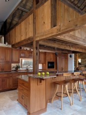 a light-stained wood kitchen with wooden beamds and tall stools is very warm and welcoming as it’s fully made of wood