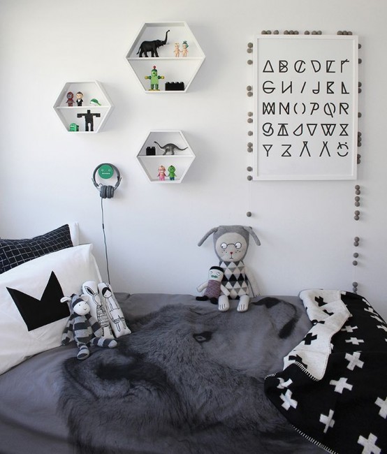 a Scandinavian kid's room with a bed, monochromatic bedding, hexagon-shaped shelves and toys and art that match the space color scheme
