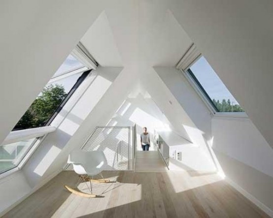 a minimalist white attic sunroom with a simple chair is an ideal space for reading or for kids' playing