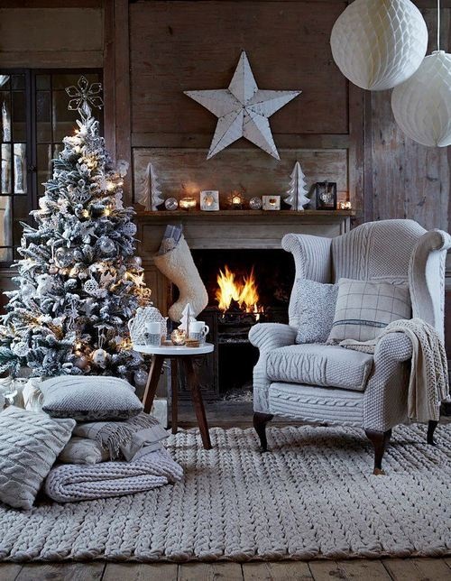 a frozen living room with a fireplace, a frozen Christmas tree with lights and metallic ornaments plus giant stars