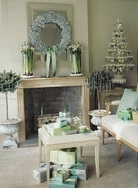 a pastel vintage living room with refined vintage holiday decor - a small tabletop tree with green and silver ornaments, a frozen light blue wreath and potted plants with icicles hanging on them