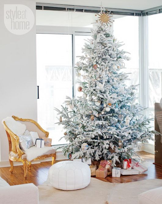 a flocked Christmas tree with silver and copper ornaments and white and silver sequin pillows for cozy holiday decor