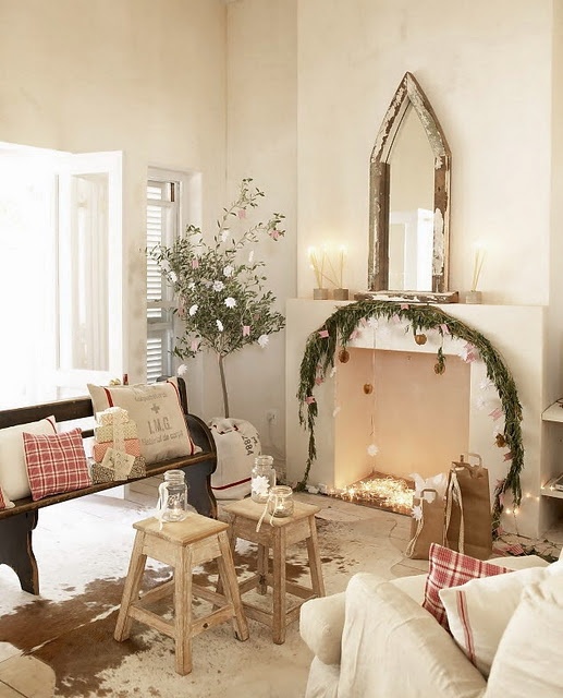 plaid pillows, some lights in the fireplace and a fir garland with ornaments make the Mediterranean space look very holiday like