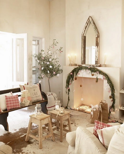 plaid pillows, some lights in the fireplace and a fir garland with ornaments make the Mediterranean space look very holiday-like