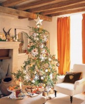 a Christmas tree with white and metallic ornaments, with dried citrus and snowflakes and stars is lovely and creates a mood here