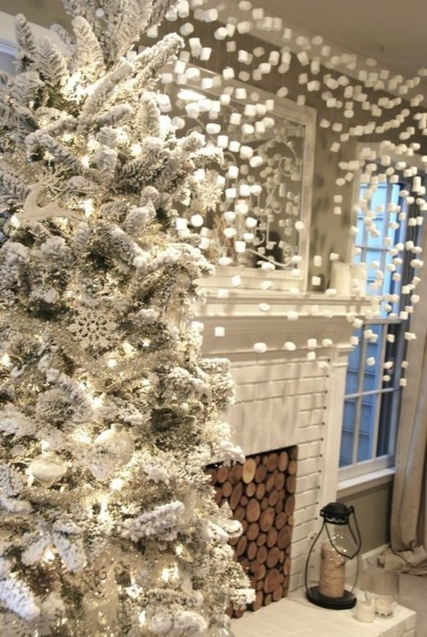 a curtain made of marshmallows and a flocked Christmas tree with lights and snowflakes create a winter wonderland here