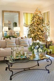 a tray with colorful ornaments, metallic candleholders, a Christmas tree with lights, metallic and white ornaments for a holiday feel in the space