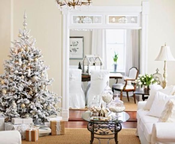 a refined flocked Christmas tree with metallic ornaments and lights sets a holiday atmosphere in the living room