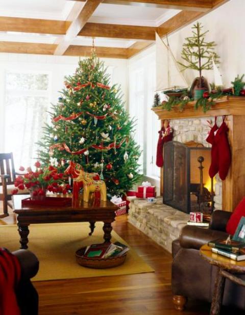 a bold red and white Christmas tree with red and white ornaments, red stockings, a fir garland with red ornaments and a potted tree