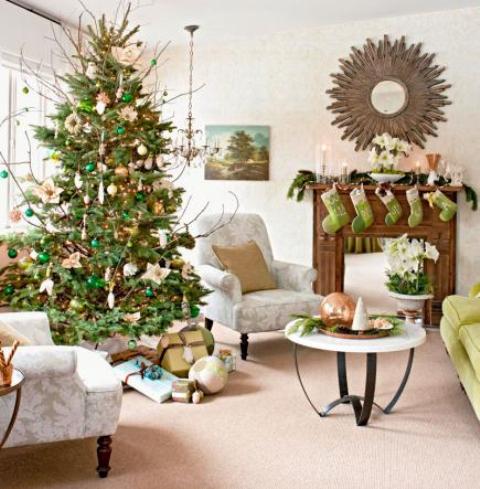 bright green stockings on the mantel, a fir garland and candles, a Christmas tree with gold and emerald ornamnets plus branches for bold holiday decor