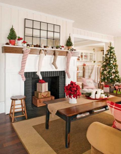 striped, white and burlap stockings on the mantel, mini Christmas trees in baskets, a Christmas tree with vine and green ornaments for holiday cheer
