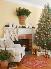 white stockings with gold stars, fir branches with pinecones in a basket, a Christmas tree with metallic vintage ornaments and beads for lovely holiday decor