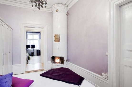 a Scandinavian entryway with blush ombre walls, a white hearth and bold pillows on the floor