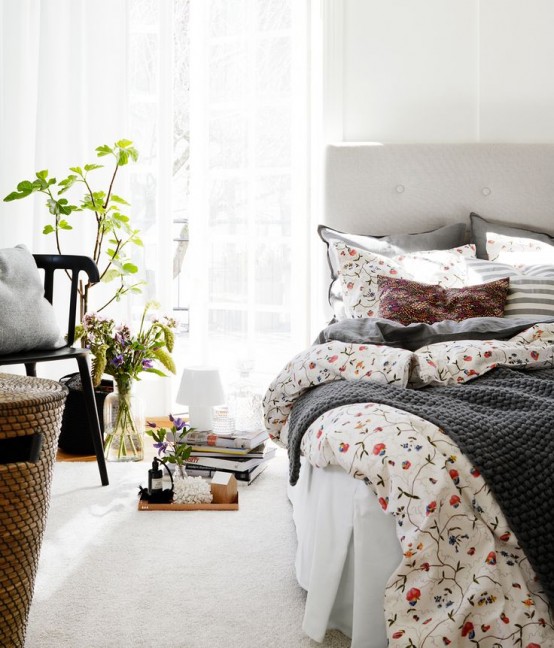 a welcoming and airy spring bedroom in neutrals, with potted greenery and plants, a basket, some floral bedding