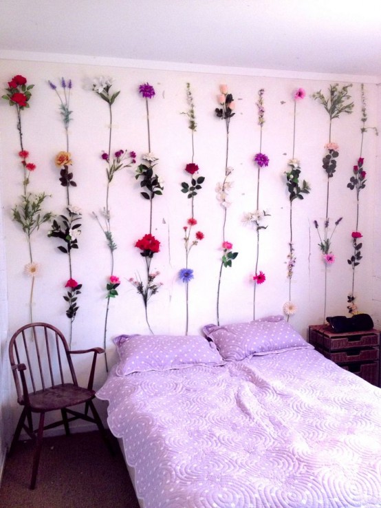 a spring bedroom with lavender polka dot bedding, faux blooms attached to the wall to make the space feel spring-like