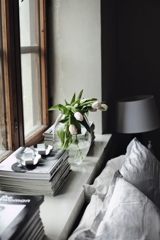 a Scandinavian bedroom in neutrals, with fresh blooms in a vase feels fresh and spring-like